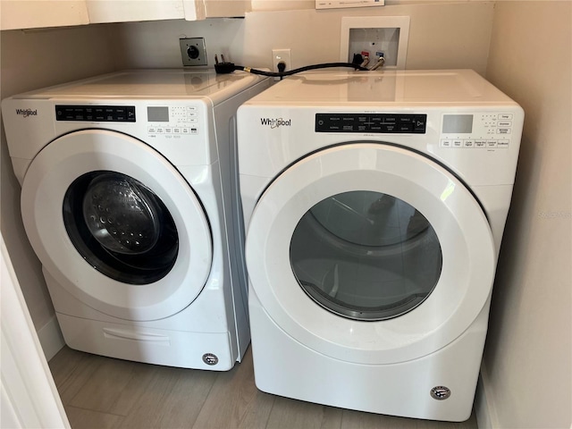 laundry area with washer and dryer, laundry area, and wood finished floors