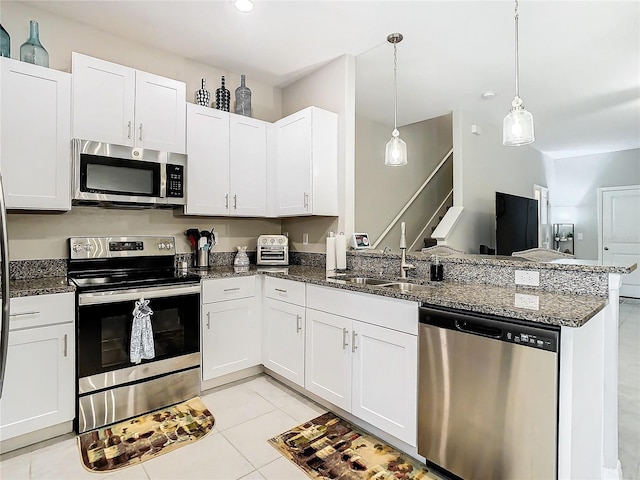 kitchen with kitchen peninsula, stainless steel appliances, light tile patterned flooring, and sink