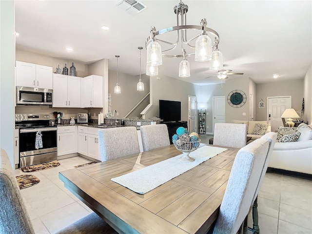 dining area featuring sink, ceiling fan, and light tile patterned floors