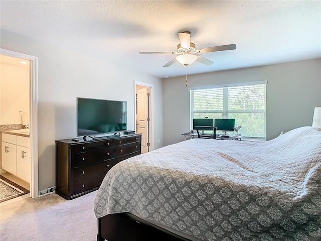 bedroom with sink, a textured ceiling, ensuite bath, ceiling fan, and light carpet