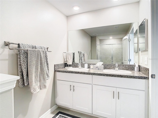 bathroom with walk in shower, dual bowl vanity, and tile patterned floors