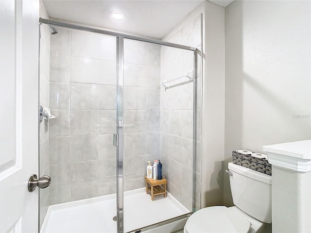 bathroom with toilet and an enclosed shower