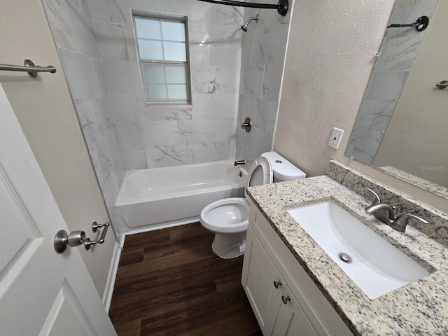 full bathroom featuring wood-type flooring, toilet, tiled shower / bath, and vanity