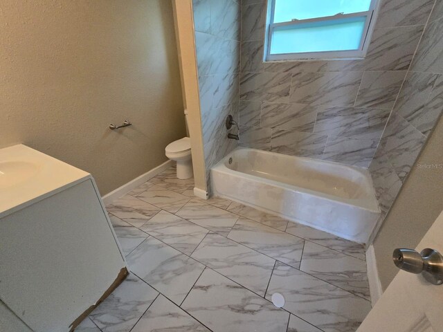 full bathroom with tile patterned floors, toilet, tiled shower / bath, and vanity