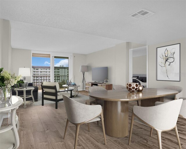 9 Haig Pl Unit 612, Dunedin, FL 34698 - dining space with a textured ceiling, visible vents, and wood finished floors