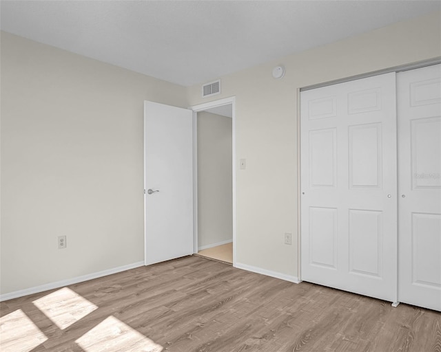 unfurnished bedroom featuring light hardwood / wood-style flooring and a closet