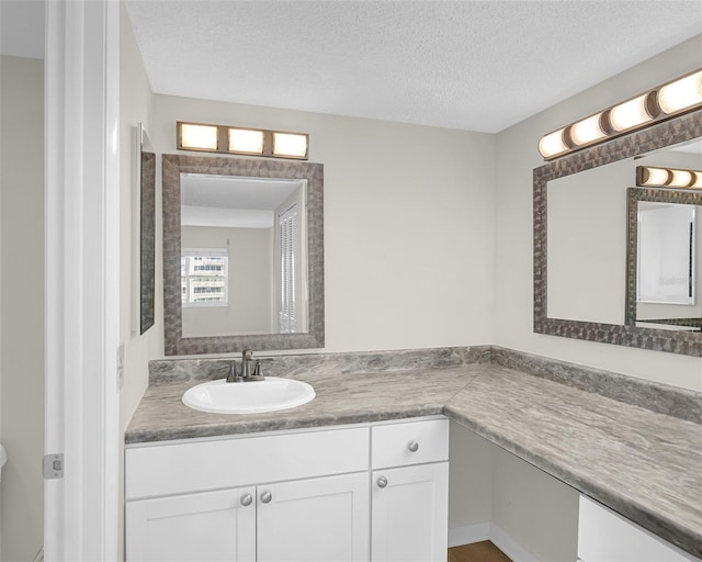 bathroom with a textured ceiling and vanity