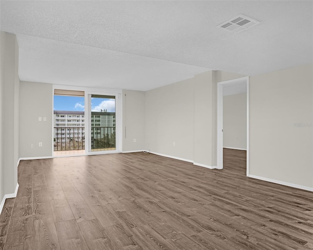9 Haig Pl Unit 612, Dunedin, FL 34698 - spare room featuring visible vents, a textured ceiling, baseboards, and wood finished floors
