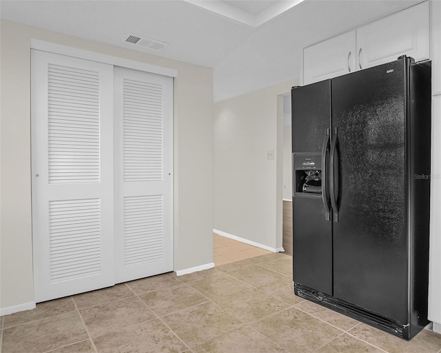 kitchen featuring white cabinetry, black fridge with ice dispenser, and light tile patterned floors