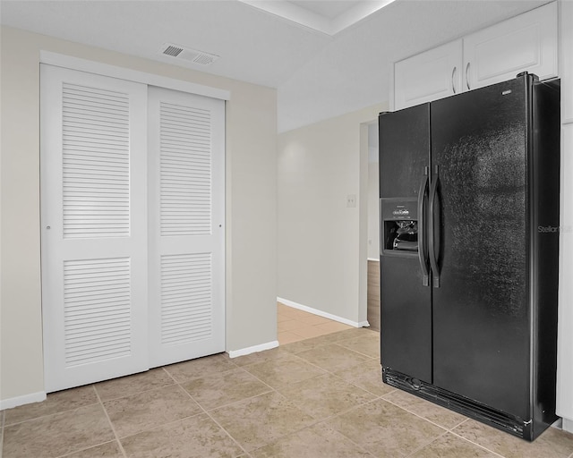 9 Haig Pl Unit 612, Dunedin, FL 34698 - kitchen featuring white cabinets, baseboards, black refrigerator with ice dispenser, and visible vents