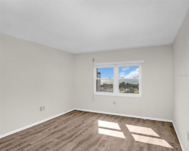 spare room featuring hardwood / wood-style flooring and a textured ceiling