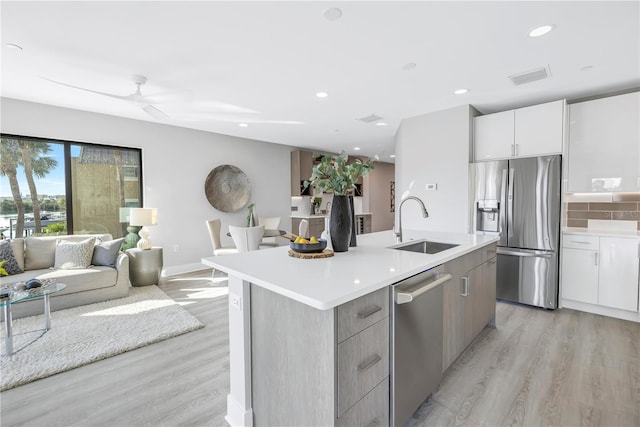 kitchen with tasteful backsplash, appliances with stainless steel finishes, open floor plan, a sink, and modern cabinets