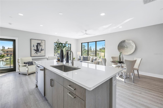 kitchen featuring light hardwood / wood-style flooring, dishwasher, an island with sink, and sink