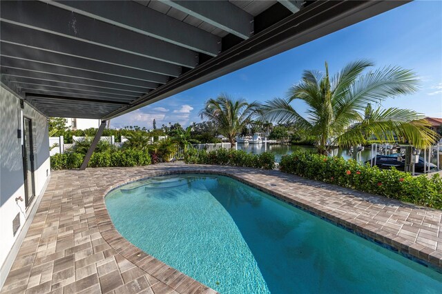 view of swimming pool featuring a water view and a patio area