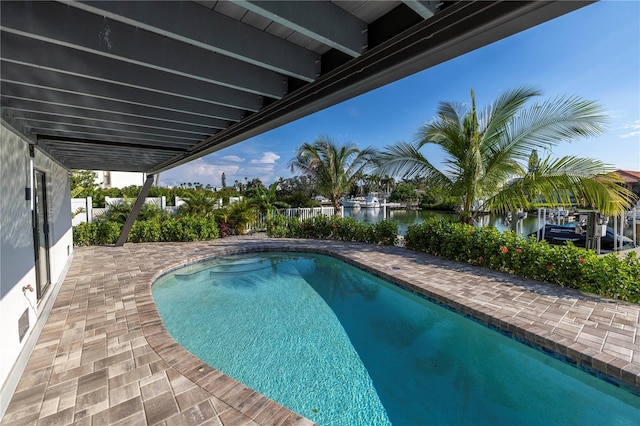 outdoor pool featuring a patio and a water view