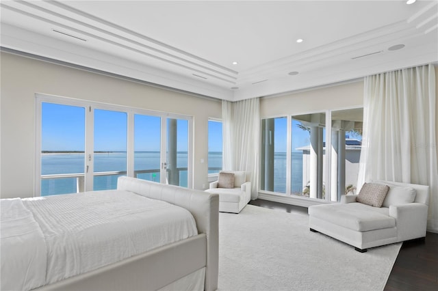 bedroom featuring recessed lighting, dark wood-style flooring, and a water view