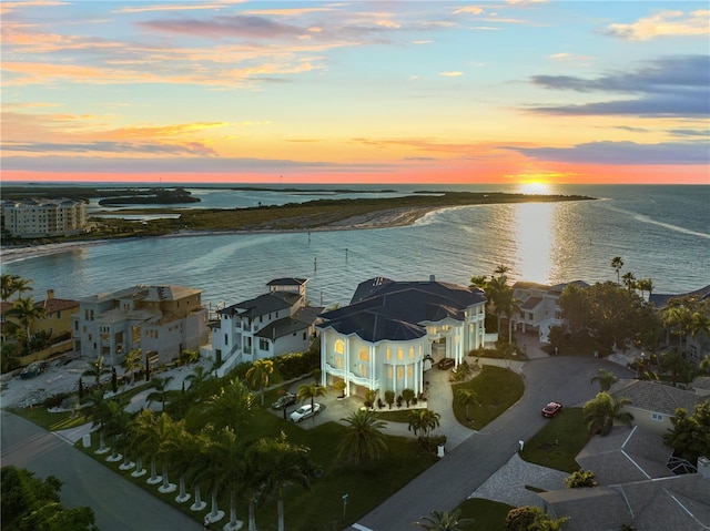 aerial view at dusk featuring a residential view and a water view