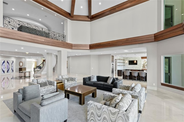 living room with a towering ceiling, stairway, and recessed lighting