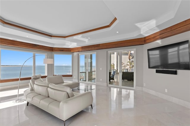 living area featuring a water view, baseboards, a tray ceiling, and ornamental molding