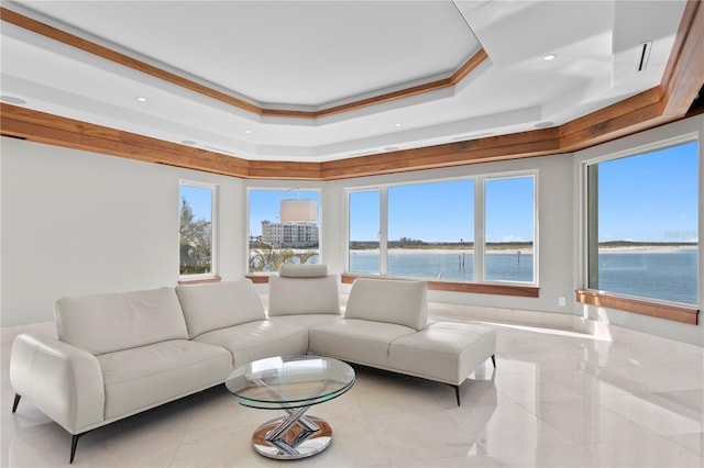 living room featuring a water view and a raised ceiling