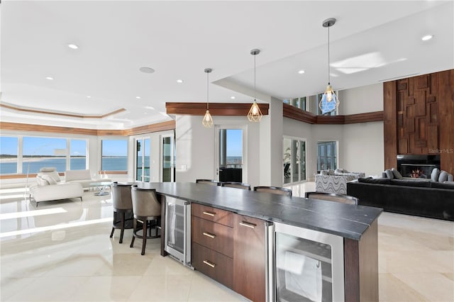 kitchen with dark countertops, wine cooler, a tray ceiling, and open floor plan