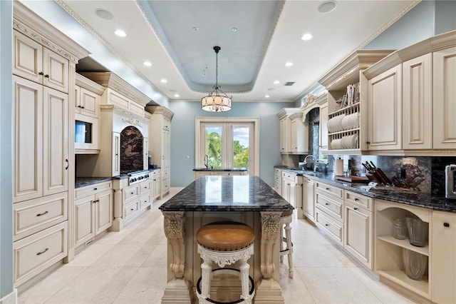 kitchen featuring open shelves, cream cabinetry, a sink, and a center island