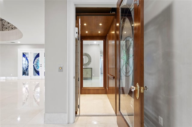 hall with light tile patterned floors, recessed lighting, elevator, and french doors