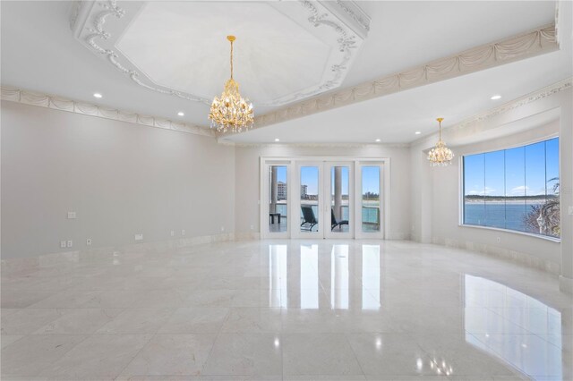 empty room featuring baseboards, french doors, a tray ceiling, and a notable chandelier