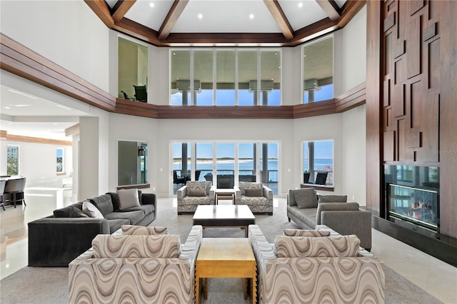 living area with beam ceiling, a towering ceiling, and a high end fireplace