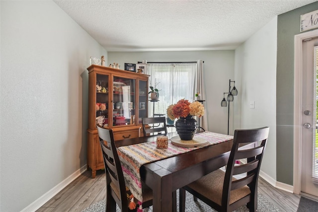 dining space with a textured ceiling and wood-type flooring