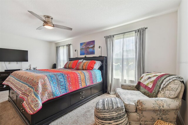 bedroom with ceiling fan, multiple windows, and carpet flooring