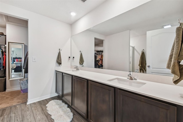 bathroom featuring dual vanity and wood-type flooring