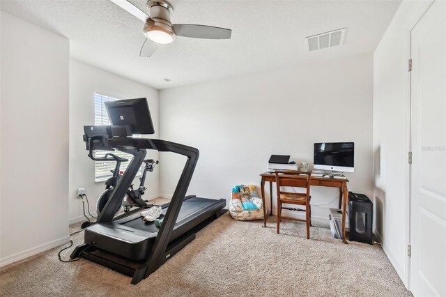 workout area featuring ceiling fan, a textured ceiling, and carpet flooring