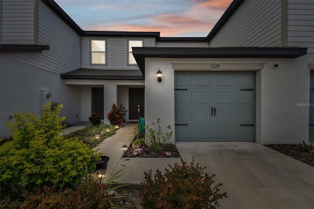 exterior entry at dusk featuring a garage