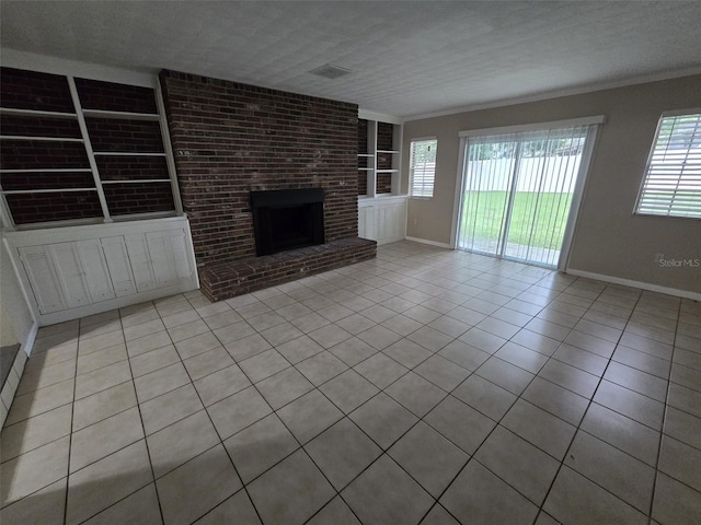 unfurnished living room featuring brick wall, crown molding, built in features, light tile patterned flooring, and a brick fireplace