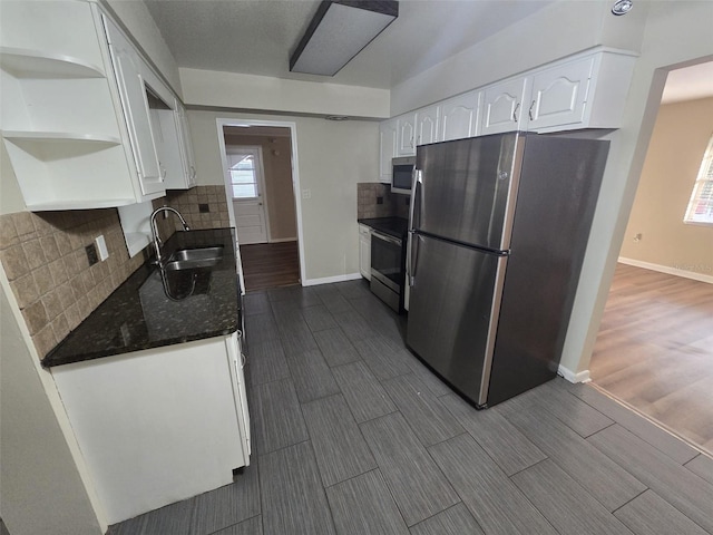 kitchen with decorative backsplash, hardwood / wood-style floors, white cabinetry, appliances with stainless steel finishes, and sink