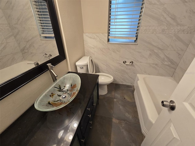 bathroom with tile patterned floors, toilet, vanity, and tile walls