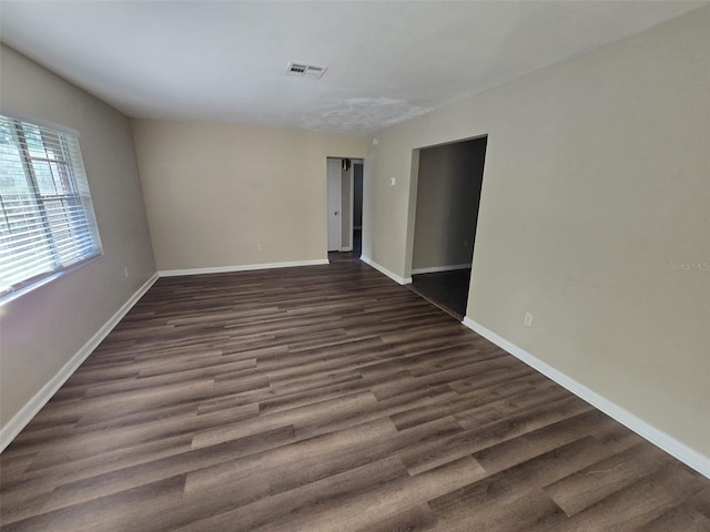 spare room featuring dark wood-type flooring