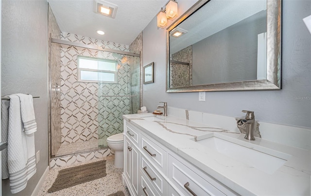 bathroom featuring toilet, a textured ceiling, vanity, and a shower with door