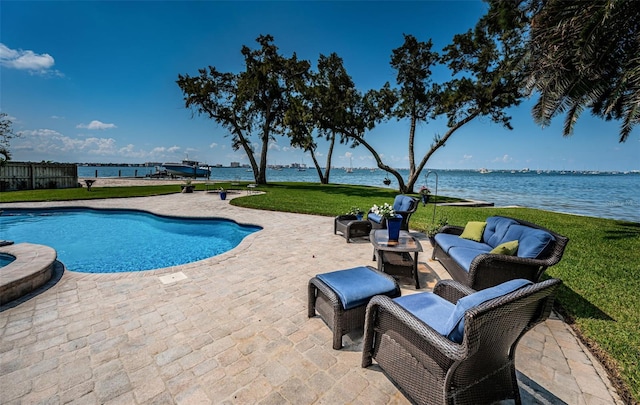 view of pool featuring a water view, a patio, and a lawn