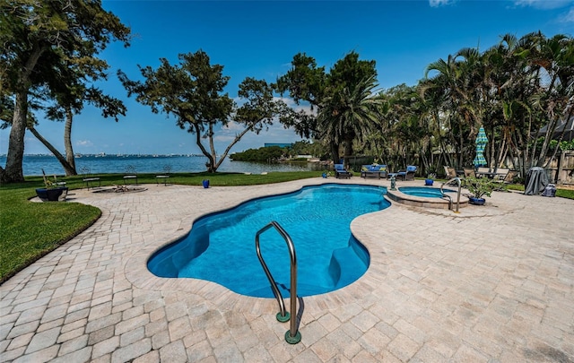 view of swimming pool featuring a patio, a water view, and an in ground hot tub