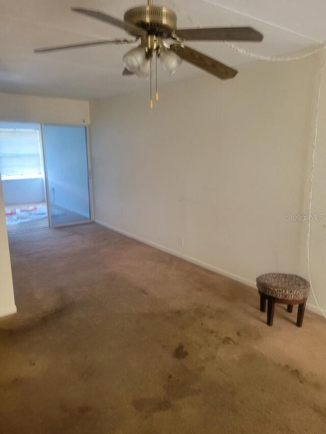 carpeted spare room with ceiling fan