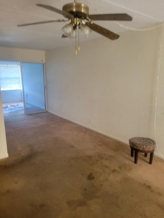 carpeted empty room featuring ceiling fan