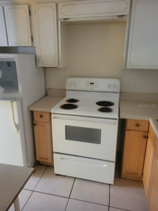 kitchen with white appliances, light tile patterned floors, and light brown cabinetry