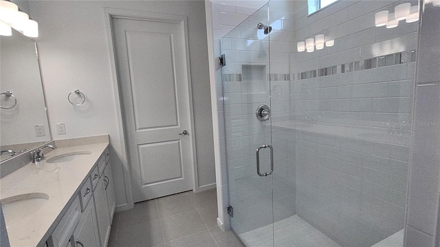 full bathroom with tile patterned flooring, a stall shower, double vanity, and a sink