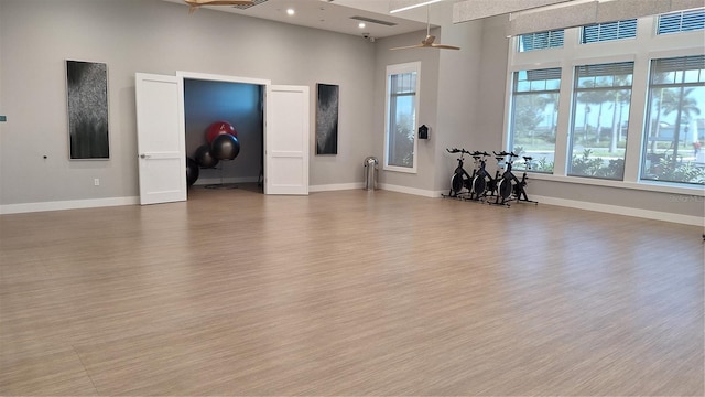 unfurnished room with a ceiling fan, baseboards, and wood finished floors