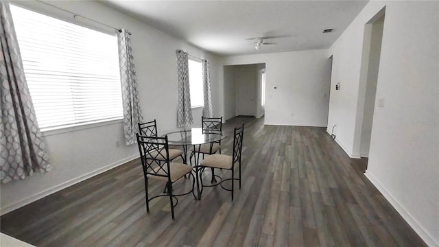 dining room featuring ceiling fan, visible vents, baseboards, and dark wood-style floors