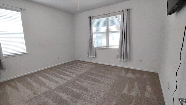 unfurnished room with baseboards and carpet flooring