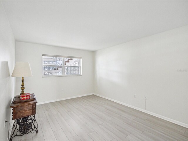 unfurnished room featuring light wood-style flooring and baseboards