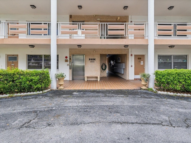 entrance to property featuring elevator, stucco siding, and brick siding